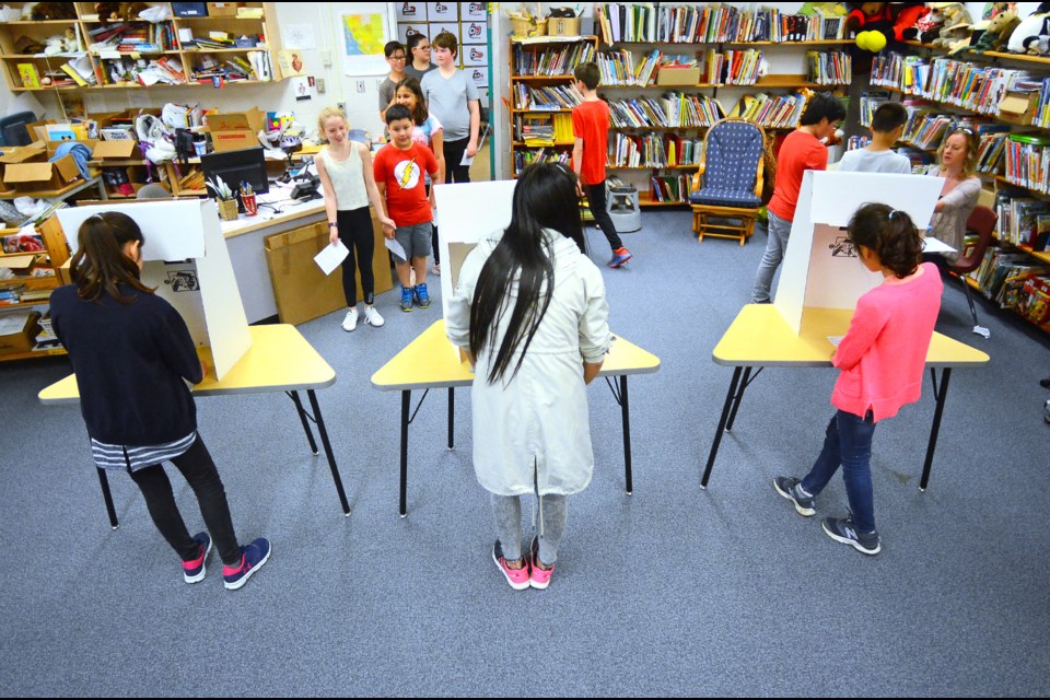 Lyndhurst Elementary School students line up to cast their ballots Monday in a parallel B.C. provincial election put on by Student Vote.