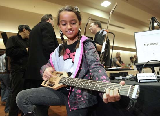 Nadia Lund tested out a mini-traveller guitar at the Vancouver Guitar Show at the Croation Cultural Centre, Nov. 25. The show featured a Swap n Shop, as well as clinics, performances, player contests and an open mic.