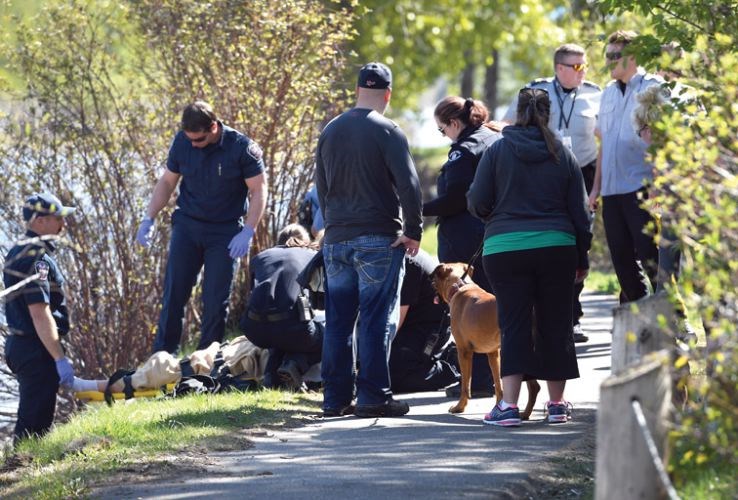 Emergency personnel help a woman who was rescued from the Nechako River this morning.