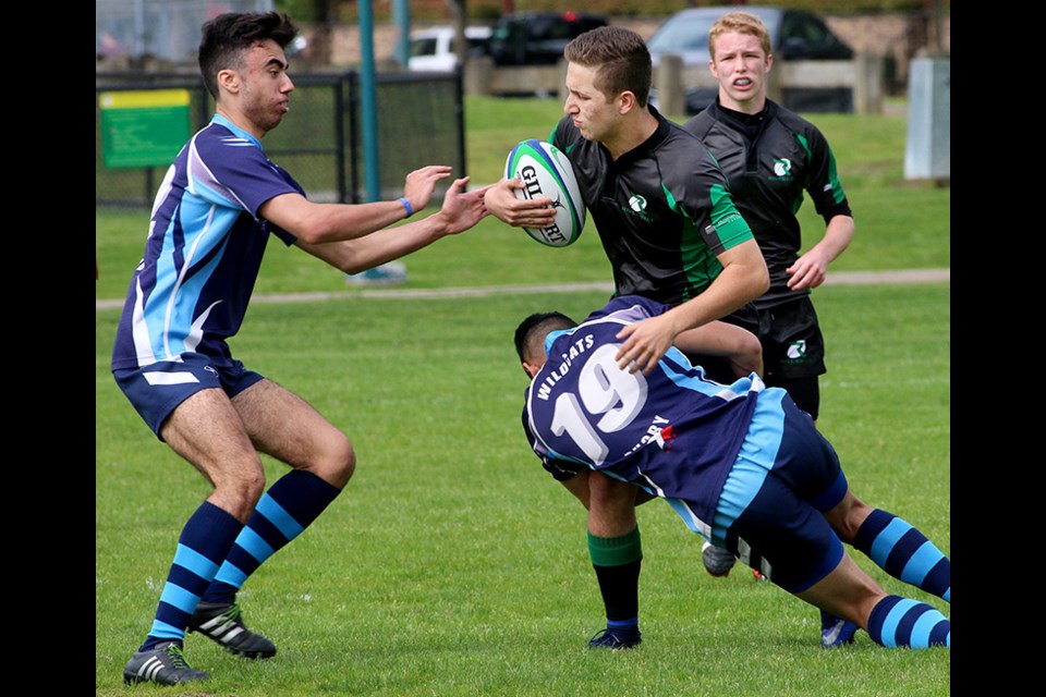 MARIO BARTEL/THE TRI-CITY NEWS A Riverside Rapids ball carrier tries to evade the clutches of Westview Wildcats defenders in the first half of their Fraser Valley District senior boys rugby final on Thursday at Gates Park.