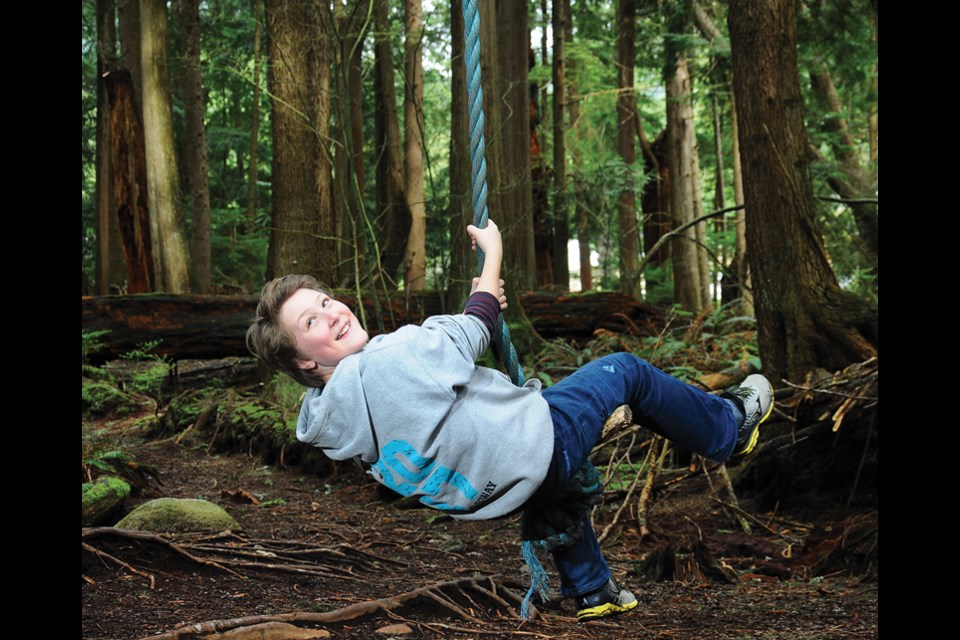 Twelve-year-old Eli Eifler swings on a giant rope tucked away in the forest near Mosquito Creek in North Vancouver.