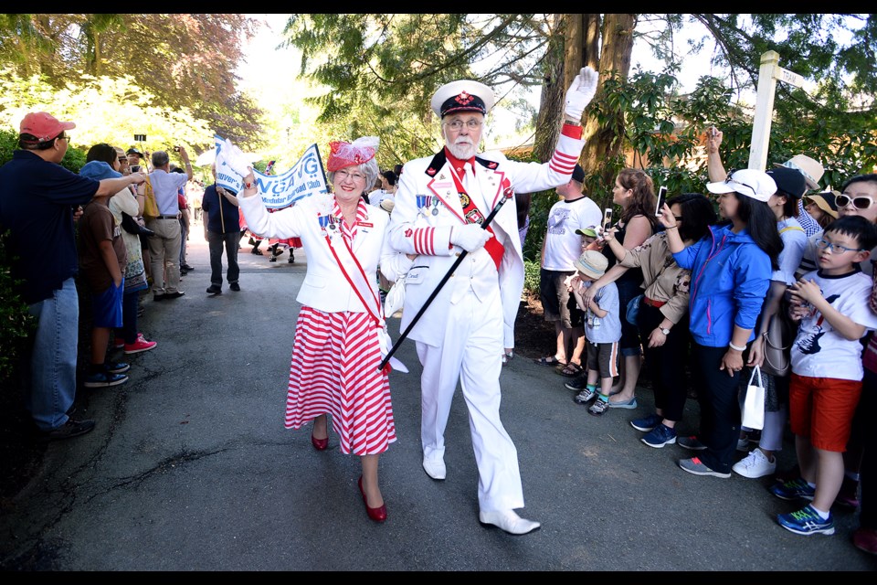 Captain and Mrs. Canada, a.k.a. Jack Hetherington and Christine Harper, lead the way during the Queen's Procession at Burnaby Village.