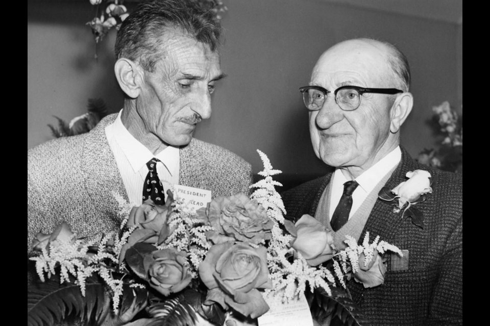 Dated June 26, 1968, this photo is captioned: “Sechelt Garden Club president Mr. Frank Read and Retired Garden Man, Mr. Tom Barber, admire the beautiful flame roses and white spirea table decoration which won the Garden Club’s special prize in the Spring Show.”