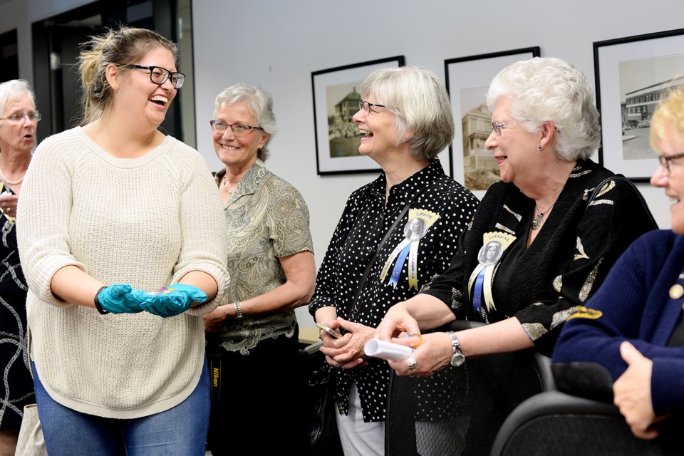 Members of the 1967 graduating class of St. Anne's Academy check out artifacts from their school, which was demolished years ago, at the New Westminster Museum.