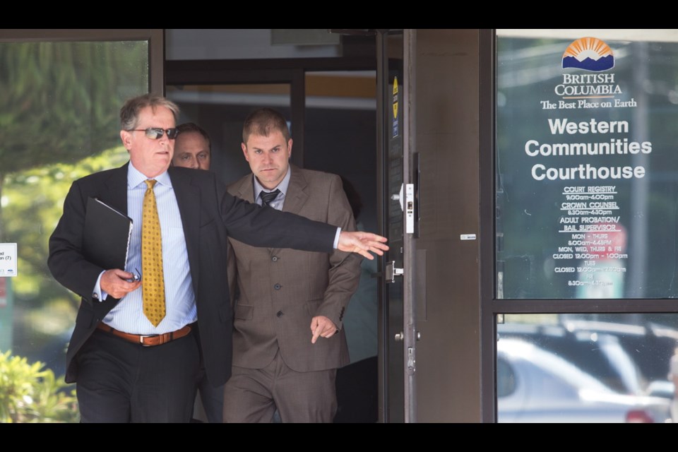 Kenneth Jacob Fenton, right, charged in the death of RCMP Const. Sarah Beckett, leaves the Western Communities Courthouse with his lawyers, Dale Marshall, front, and Chris Massey.