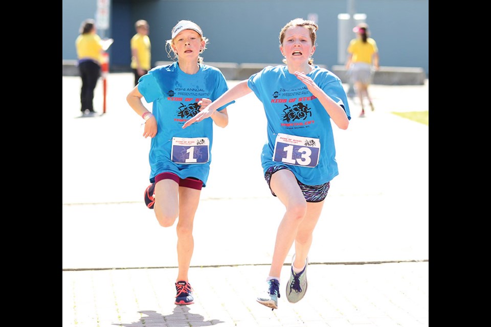 Claire Finch, right, crosses the finish line one second ahead of Stephanie Arronge at the Integris Kids of Steel Triathlon Sunday morning at Canada Games Plaza. Finch, 13, completed the 300-metre swim, eight-kilometre bike and 2.6 km run in 40:56 to finish third in the 12-13-year-old girls category, won in 38:18 by Grace Turner. A total of 144 competitors entered the 23rd annual race.