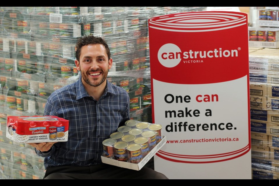 Christopher Mavrikos, the founder of Dahlia Society, beside his fundraising competition Canstruction.