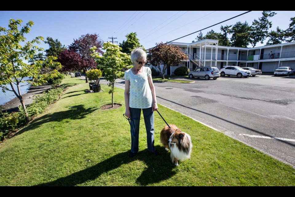 Judith Newnham walks with her Shetland sheepdog, Bo, near her Christie Point apartment block, one of nine two-storey buildings on the narrow peninsula in View Royal.