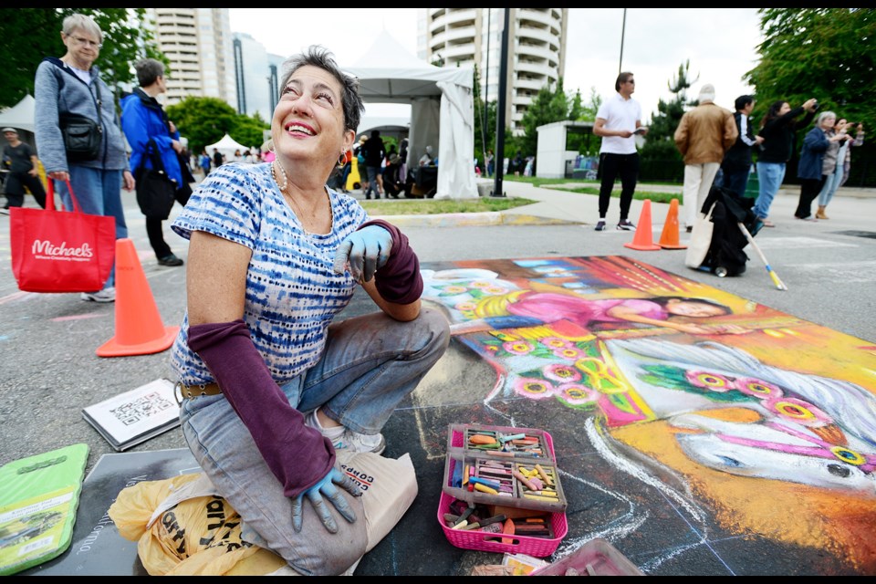 Lori Escalera, an artist from Vista, California, creates her work during the Chalk Art Festival.