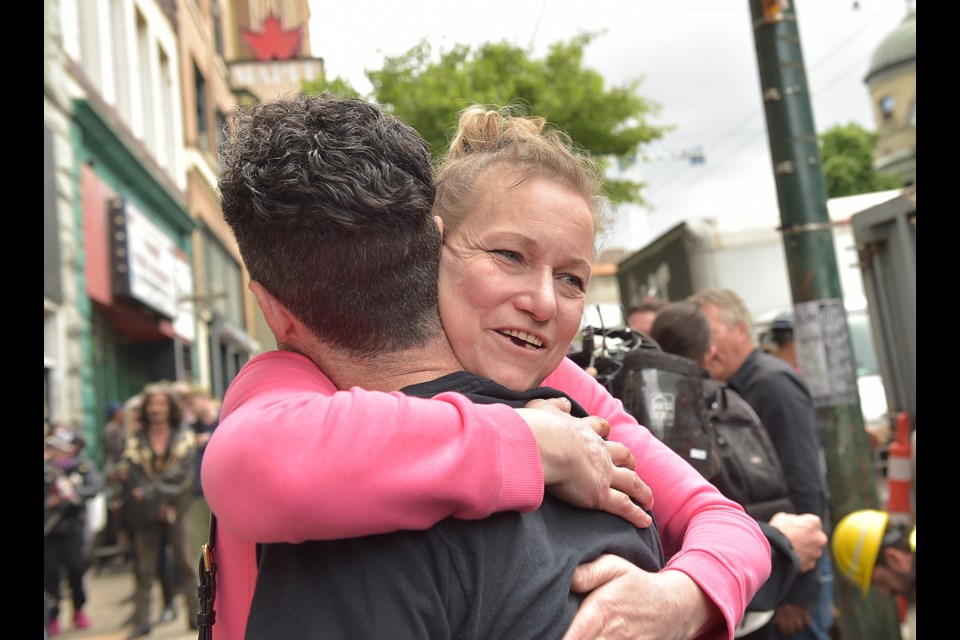 Roberta Westenberg, 57, hugs a friend outside the Balmoral Hotel on East Hastings Street after learning she would be moved to another hotel in the neighbourhood. Photo Dan Toulgoet