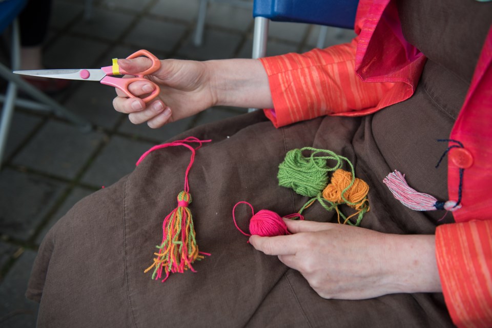 Artist and long-time Britannia arts contractor and instructor Helen Spaxman makes a tassel at Britannia Community Centre during the local version of International Yarn Bombing Day, Saturday. Photo: Rebecca Blissett