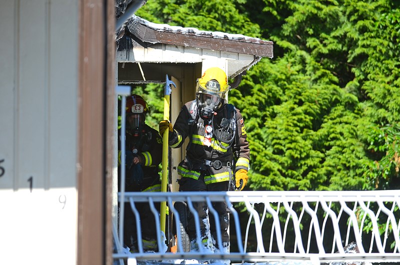 New Westminster firefighters prepare to enter a west end house to check for hot spots after the house went up in flames Monday.