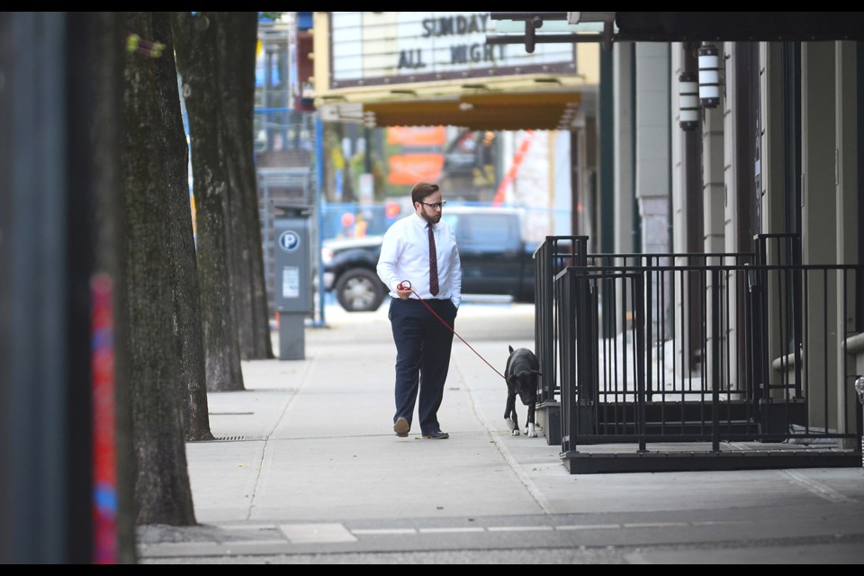 Downtown resident Alex Boland and his dog Socks take a pre-work, morning walk on Columbia Street.