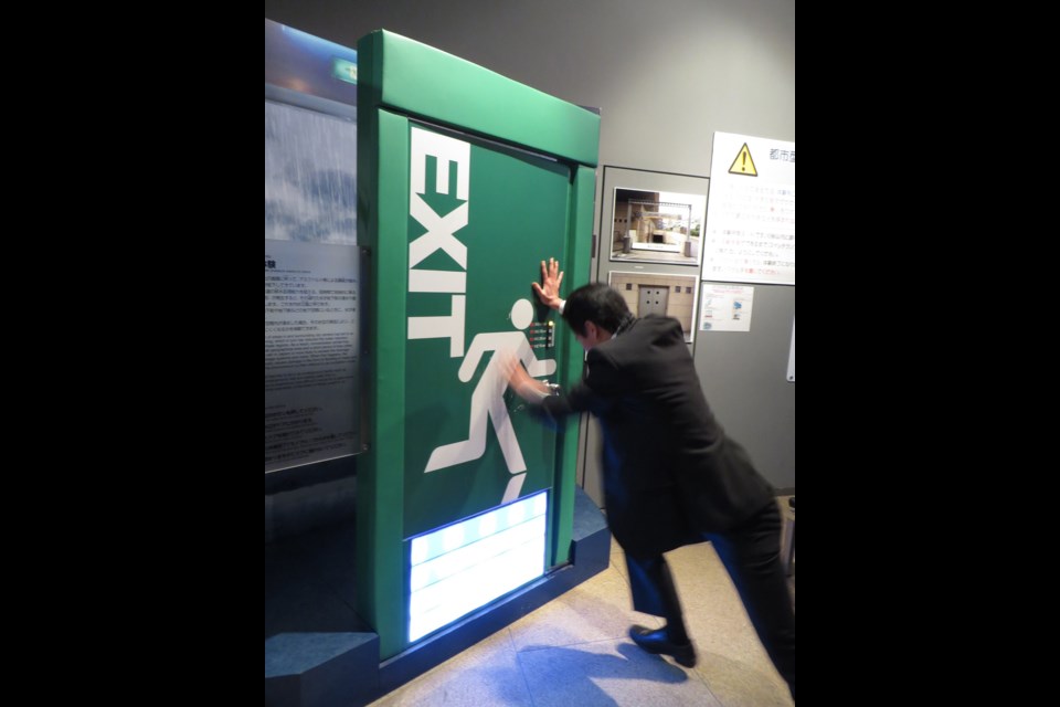 In addition to earthquakes and typhoons, Japan's disaster-education centres also teach citizens to deal with more common emergencies, such as fires and flooding. Here, a visitor strains to open a door that simulates the resistance created by standing water.