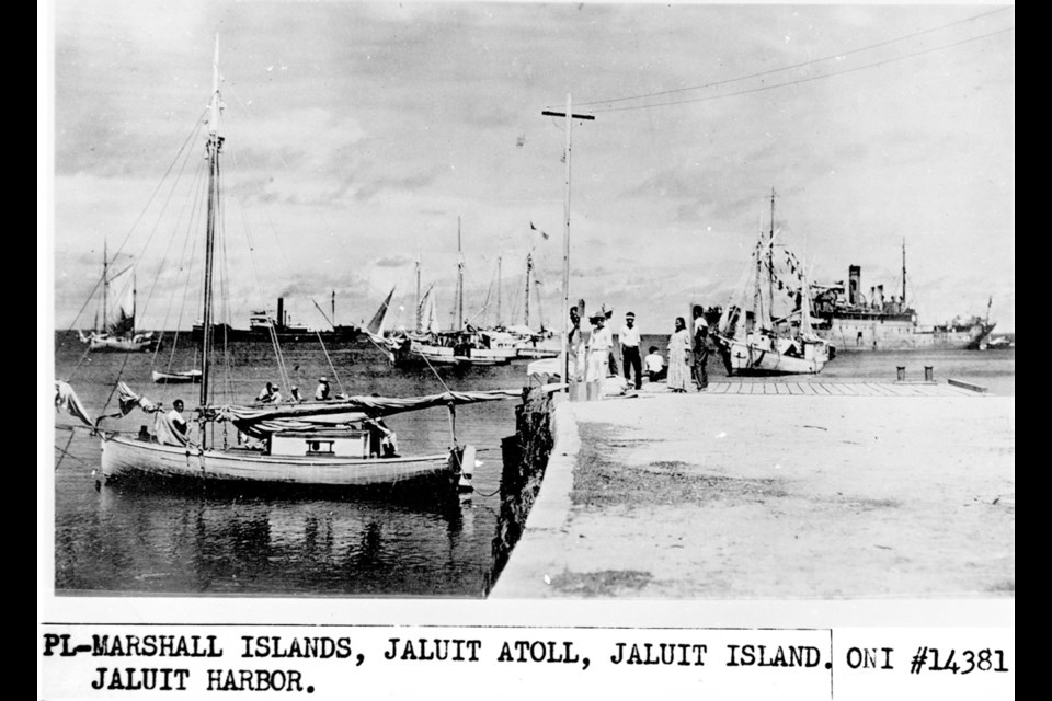 This undated photo discovered in the U.S. National Archives by Les Kinney shows people on a dock in Jaluit Atoll, Marshall Islands. The documentary Amelia Earhart: The Lost Evidence proposes that this image shows aviator Amelia Earhart, seated third from right, gazing at what may be her crippled aircraft loaded on a barge. Office of Naval Intelligence/U.S. National Archives