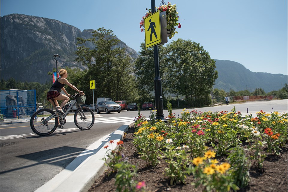 A woman rides down the newly paved surface of Cleveland Avenue on Friday afternoon. The intersection reopened last week after receiving a major face-lift that included underground infrastructure improvements.