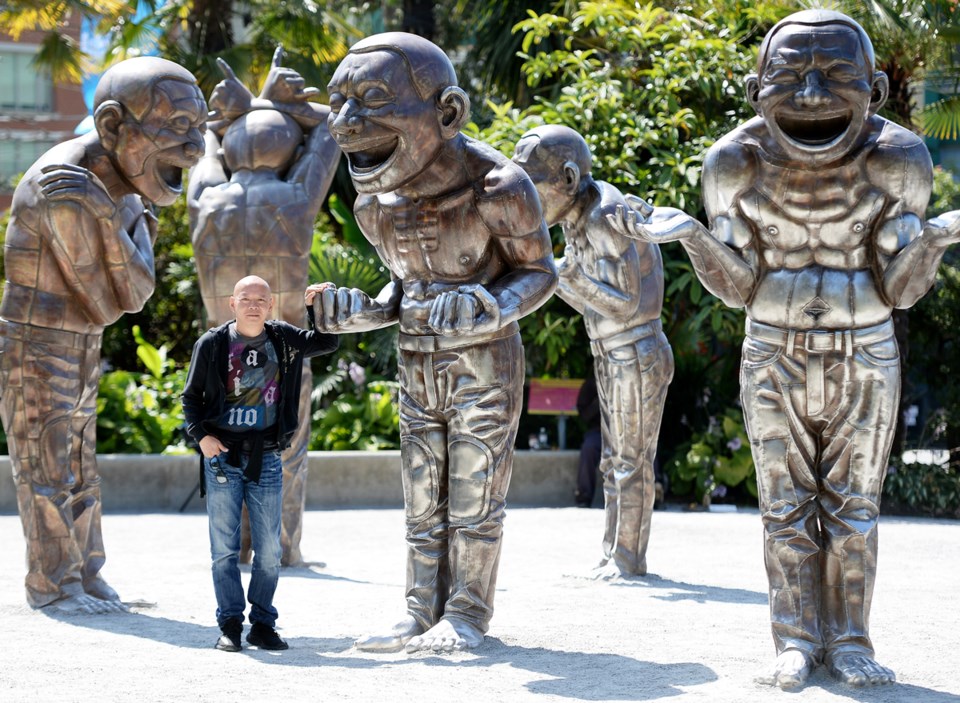 A-maze-ing Laughter, is made up of 14 giant smiling bronze men, all featuring artist Yue Minjun’s sm