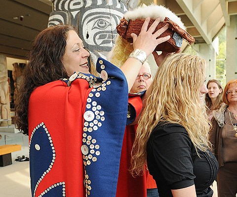 Yvonne Godkin passes the cedar head ring that once belonged to her grandmother Mabel Stanley, to a family member prior to a ceremony at the Museum of Anthropology at UBC Monday.