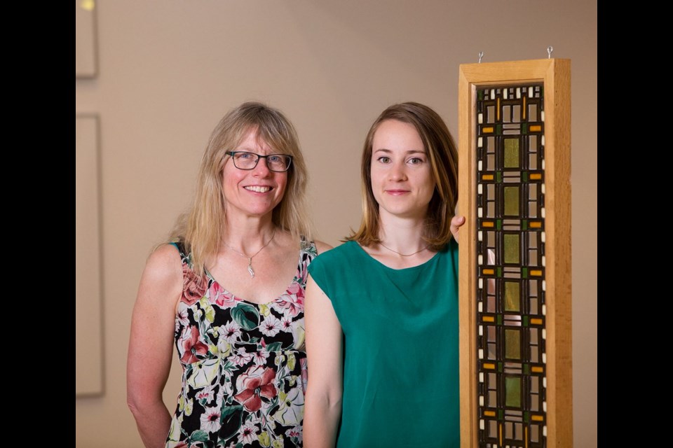 Mary Jo Hughes, left, director of UVic's Legacy Art Galleries, and Emerald Johnstone-Bedell with “Stair Landing Laylight, East."