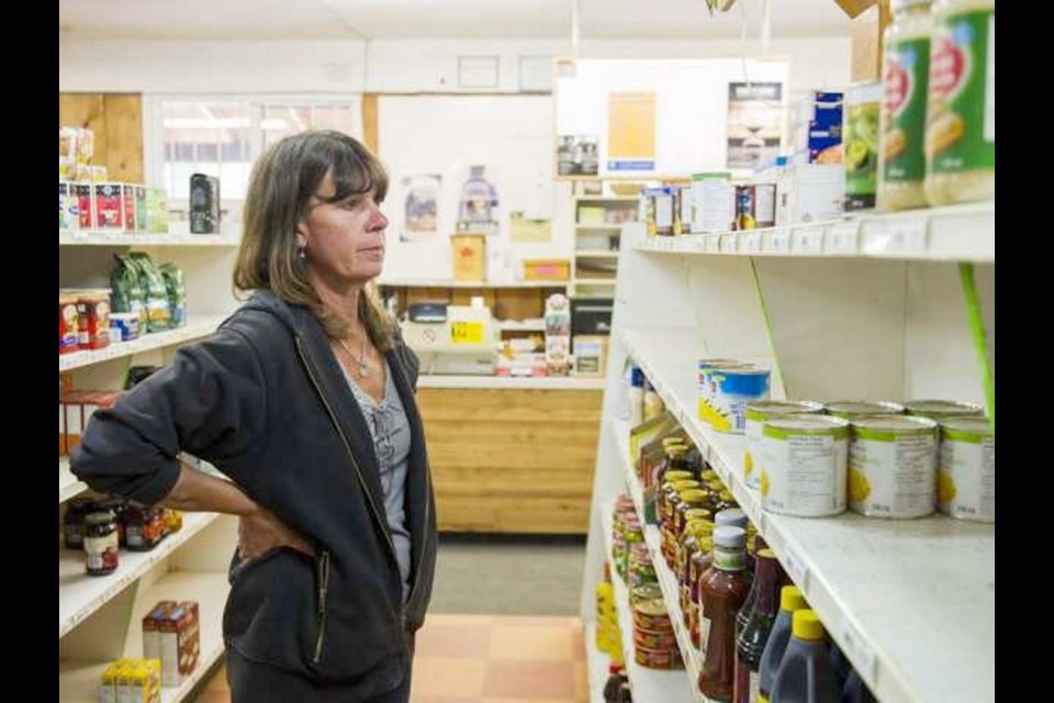 Lisa McInnes stares at a near-empty shelf while working at Clarke';s General Store in Horsefly. "It's getting pretty thin," she says.