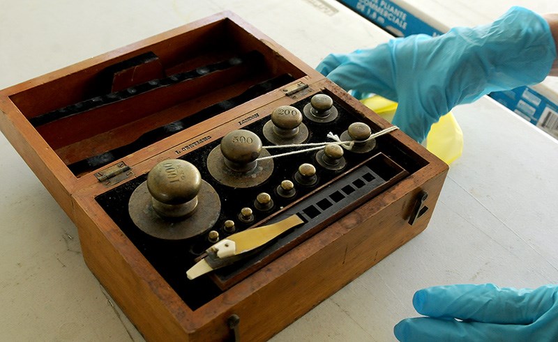 Curator Lisa Codd shows the turn-of-the-century brass weights used at Riverview Hospital in Coquitlam, used to measure powder prescriptions.