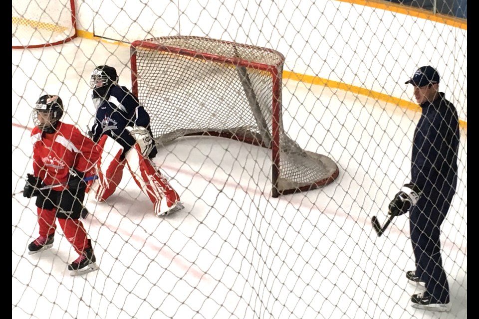 Carter Chow provides a screen in front of the net while Sidney Crosby looks on during a drill at the Pittsburgh Penguins superstar's annual summer hockey school in Cole Harbour, Nova Scotia. Chow was one of just three B.C. players awarded a spot in the camp.