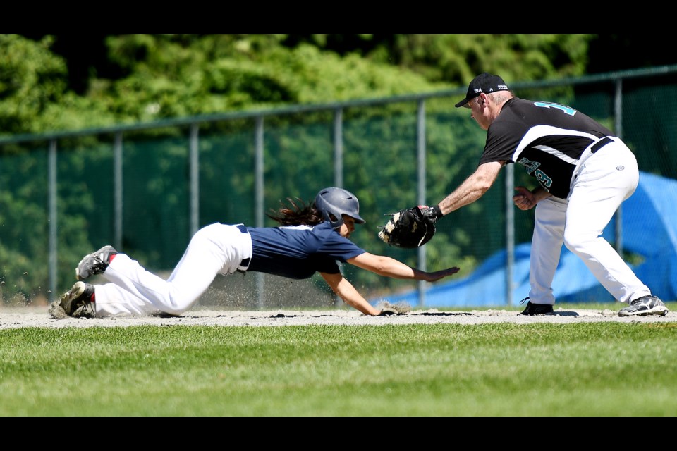 Team B.C. base runner and SFU grad Marina DeAngelis, left, dives back to first during the team’s final prep last week for this week’s Canadian Women’s Invitational Baseball Championships in Windsor.