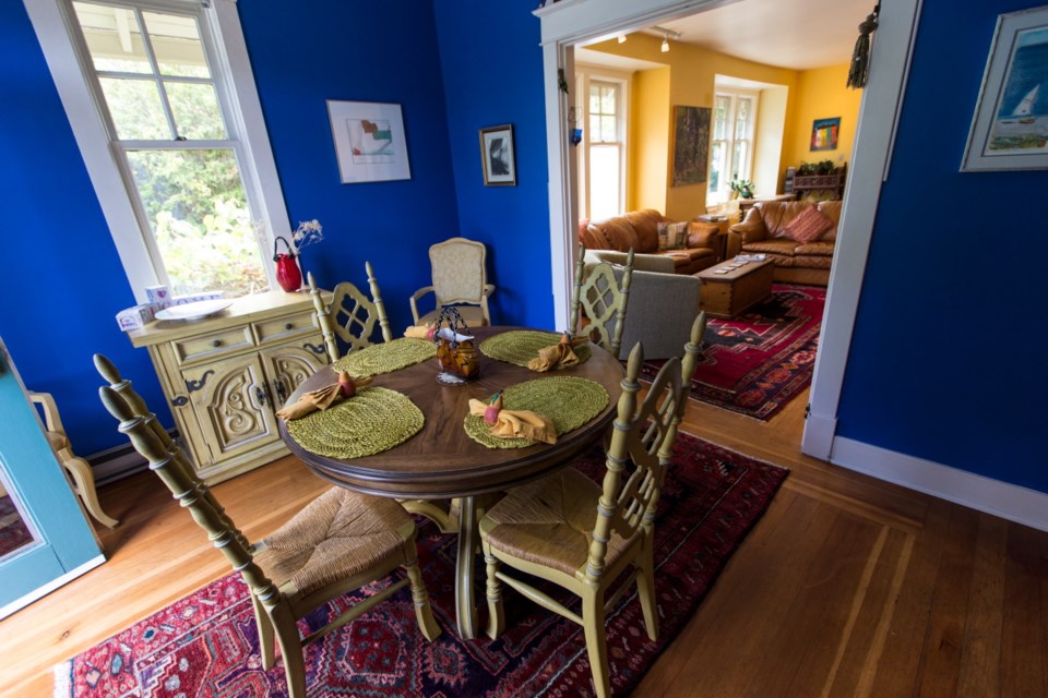 The dining-room walls are an intense blue, inspired by the Greek islands, and contrast with the pale citron-coloured Thomasville dining set. The table is round, but expands to seat 12. The antique European-style buffet has intricate filigree metalwork and carvings and the chairs have woven straw seats.