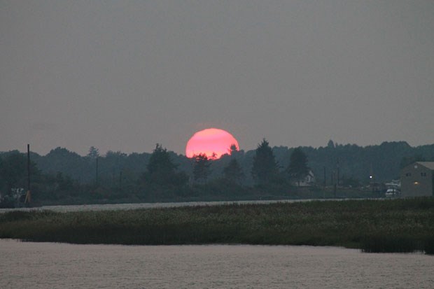 Smoke from the wildfires turned the sun into a colourful ball as it set over Ladner’s Wellington Point Park last week.