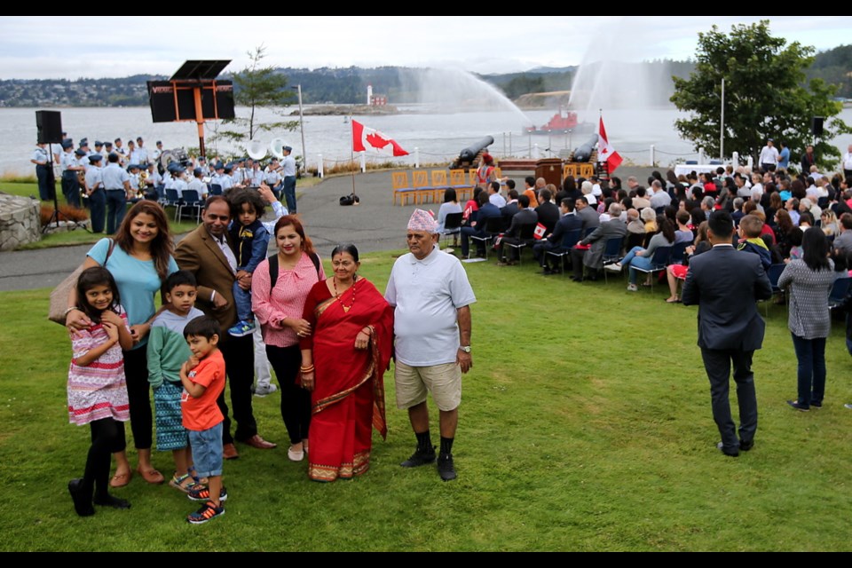 The Sharma family has their photo taken at a citizenship ceremony on Wednesday at Duntze Head, with a view of the navy harbour at CFB Esquimalt. At the ceremony, 85 people from 23 countries recited the oath of Canadian citizenship.