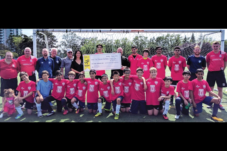 Richmond FC chair Rein Weber, staff and players presented a cheque for $5,171 to Richmond KidSport chapter on Monday, representing donations for this week’s camp at Minoru Park being run by Stoke City FC coaches. Accepting the donation is Richmond Kidsport chair Bob Jackson and director Alexa Loo.