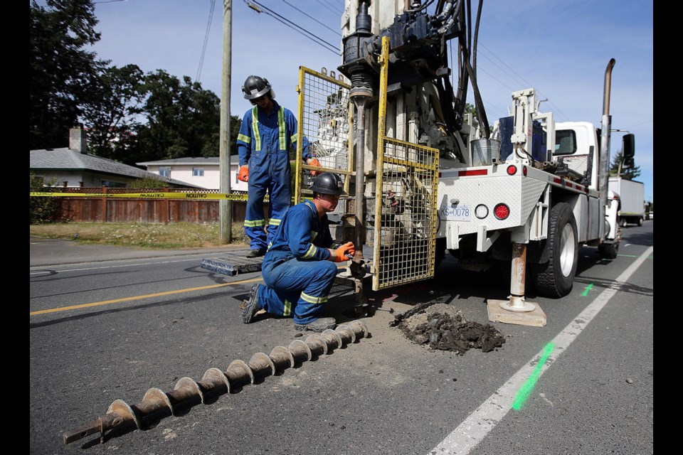 Tim Truphet, left, and Mitch Olsen of Geotech Drilling Services Ltd. work on a borehole at Interurban and Grange roads in Saanich.