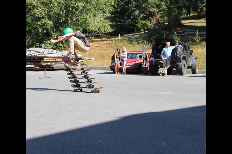 RAD Demo Skates Team member Colby Dion clears a pile of five skateboards stacked on top of one another.