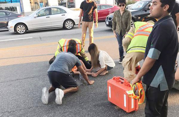 Witnesses and emergency personnel come to the aid of the pedestrian struck by a car Monday evening on Bridgeport Road. Photo submitted