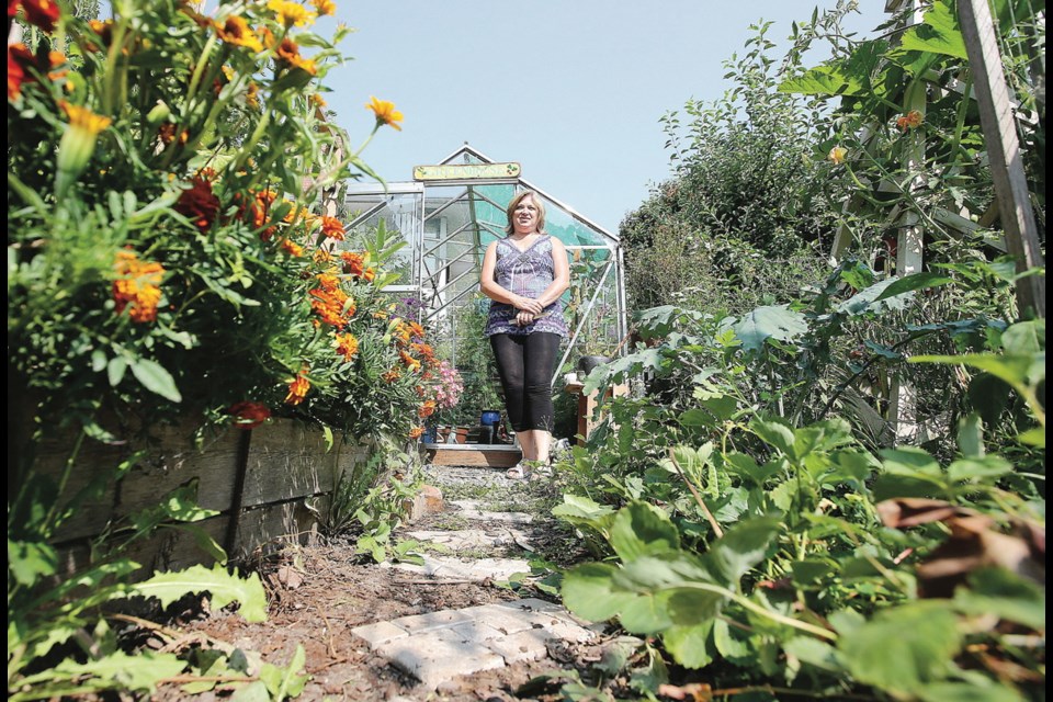 A fragrant walkway leads to the greenhouse, where Sheila Jones starts her plants.