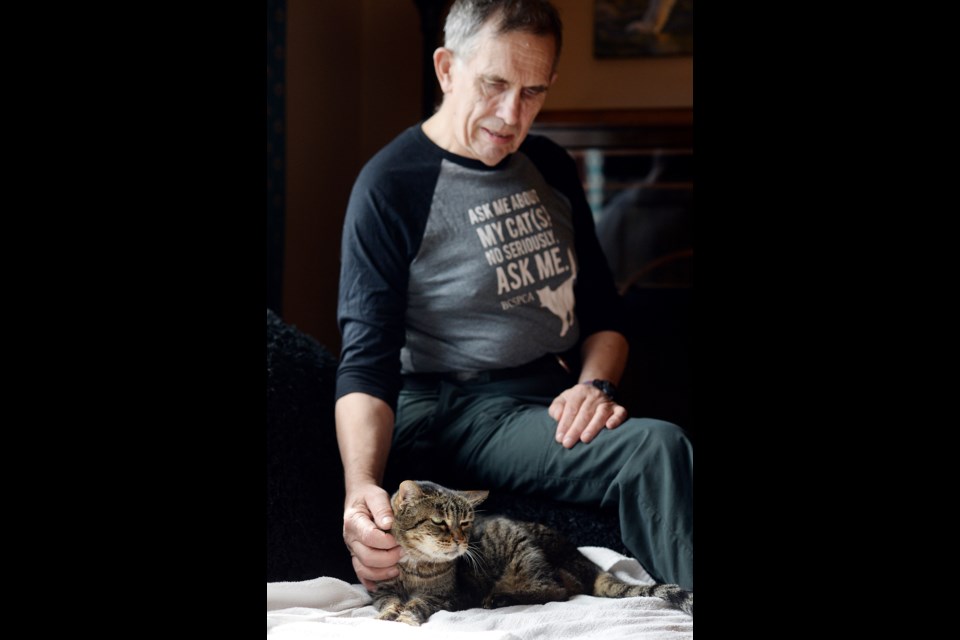 Frank Norman with his 25-year-old cat, Sabrina.
