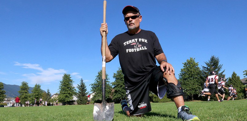 MARIO BARTEL/THE TRI-CITY NEWS Terry Fox Ravens football coach Martin McDonnell keeps a shovel in the team's storage locker to deal with potholes and dog waste he often finds on the field before practice.