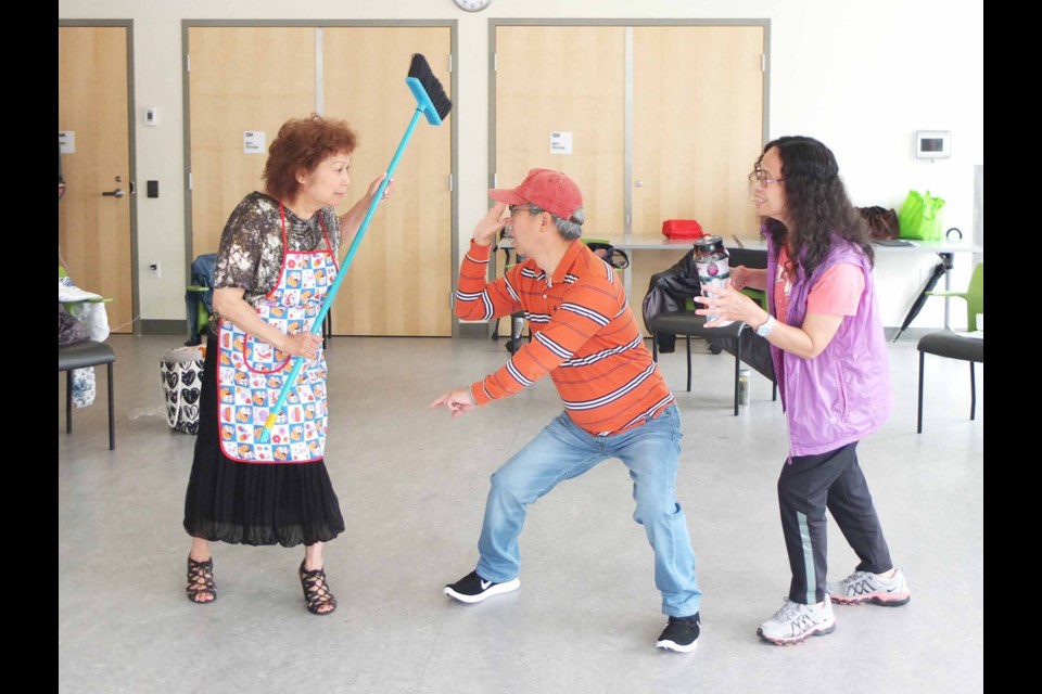 A ‘husband’ (centre) gets into trouble from his stage wife (left) for spending all their hard-earned on gambling. The drama is part of a program being run to illustrate and identify the problems excessive gambling can cause among the senior population. Photo by Daisy Xiong/Richmond News
