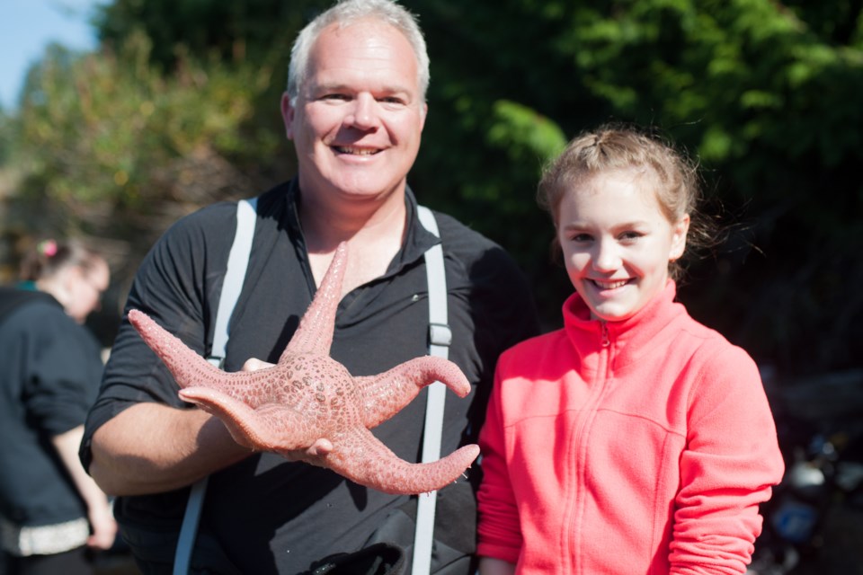 Adam Taylor holds a Spiny Pink Sea Star and stands beside his niece Nikki Taylor. Spiny Pink Stars are common on soft bottom habitat around Bowen’s shores.