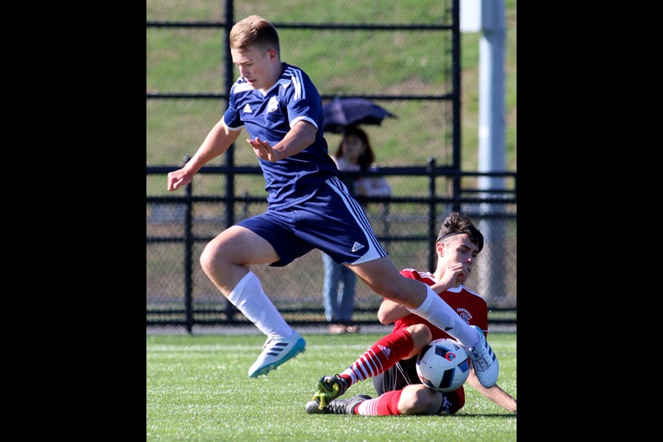 MARIO BARTEL/THE TRI-CITY NEWS
Centennial Centaurs defender Adam Almasy makes a sliding tackle to take the ball from Riverside Rapids' forward Cole Rosenlund in the first half of their Fraser Valley Secondary Schools Soccer Association match, Tuesday at Coquitlam's Town Centre.