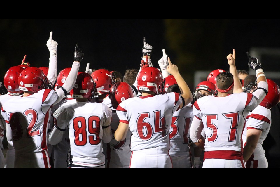 Members of the St. Thomas More Knights point skyward after their victory over the Terry Fox Ravens Friday to honour their late coach, Bernie Kully, who passed away from throat cancer on Sept. 30.