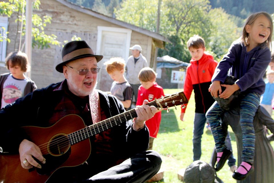 Bob Doucet plays the tunes for the traditional cake walk at Applefest. Madison enjoys the music...