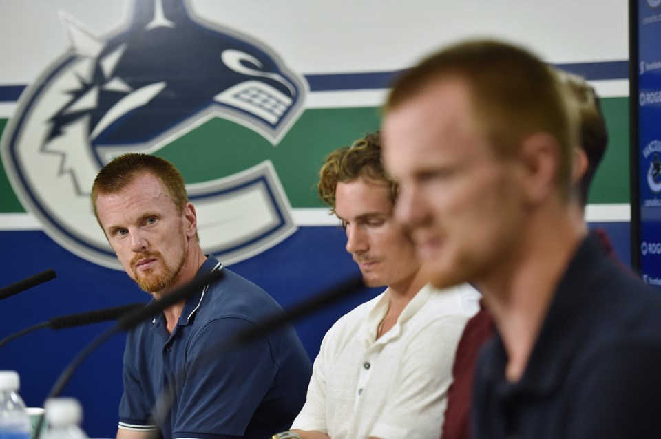 Daniel Sedin looks at Henrik Sedin, while Loui Eriksson laments some sort of inner pain.
