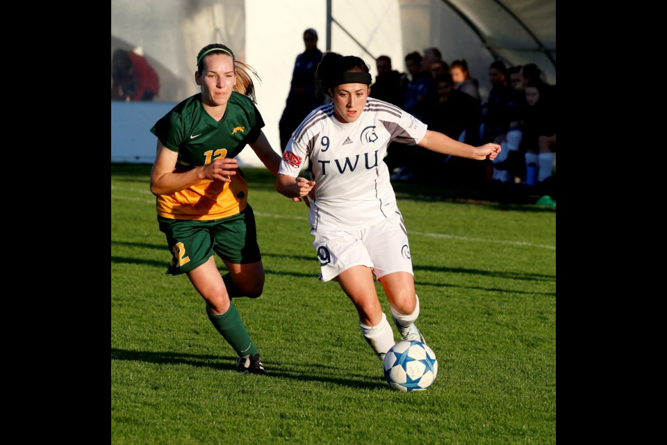 Burnaby native Seina Kashima, at right, moves the ball forward for the Trinity Western University Spartans last week. The fourth-year player will set a new Canada West career assist record with her next helper.