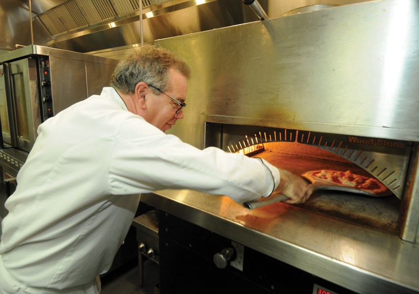 Chef Rob Parrot slides a pizza into the oven at La Sorella di Mangia in West Vancouver.