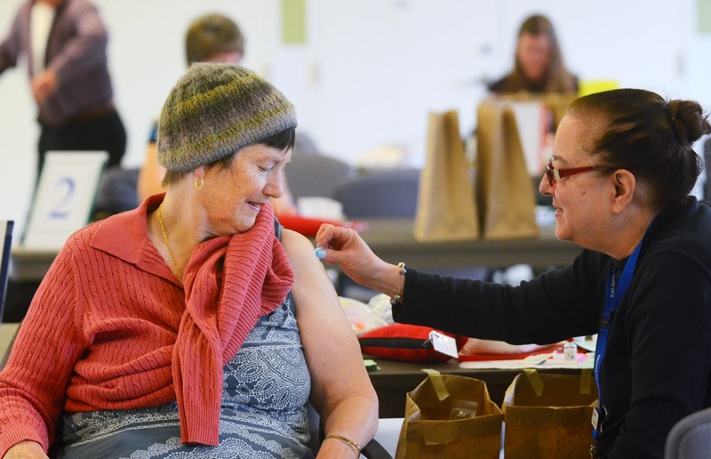 Karen Purdy, left, prepares to get a flu shot shot from nurse Karen Yoshioka at a Fraser Health flu clinic at the Bonsor 55+ centre last Thursday ( Oct. 26).