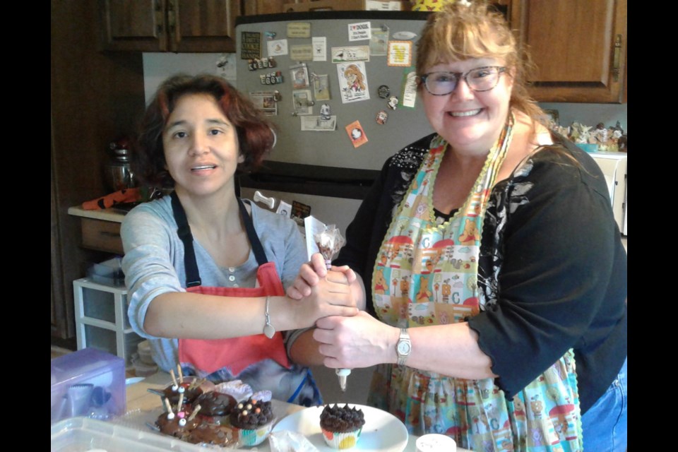 Kelly Hudson is helping her guest Stephanie make kitty cat cupcakes in her house. Photo submitted