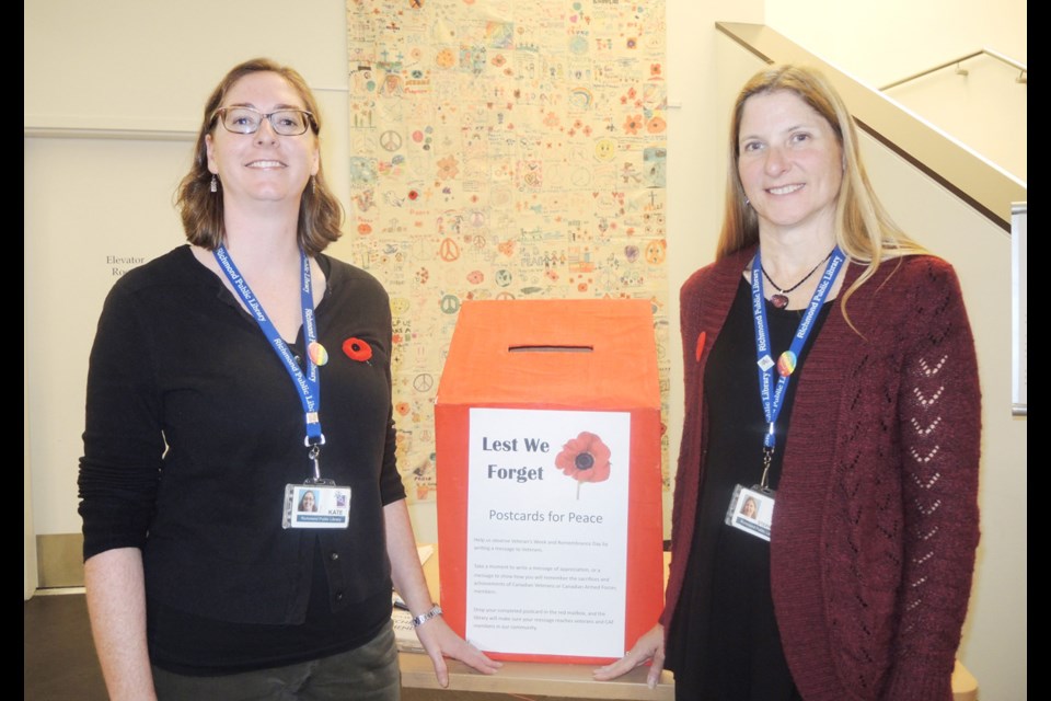 Richmond Public Library’s Kate Adams (above, left), head of Kids’ Place, and Stephanie Vokey, marketing and public relations coordinator, stand next to the library’s Postcards for Peace box. From now until Remembrance Day, people can write messages of support and peace on the cards, which will be sent to members of the Canadian armed forces and veterans. Photo by Alan Campbell/Richmond News