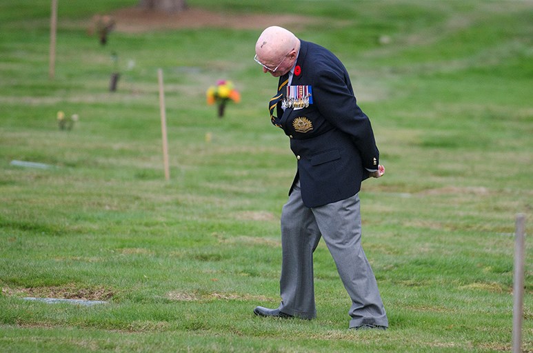 Retired colonel Leslie Deane reads the grave markers of veterans buried at Burnaby’s Forest Lawn Cemetery.