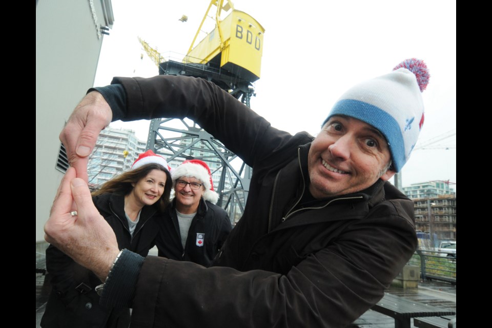 Lower Lonsdale Business Improvement Area executive director Greg Holmes spins a vision of the Sky Wheel for BIA buddies Mitra Sawyer and Andrew Klaver. The BIA is sponsoring a ferris wheel-style ride at the city’s Shipbuilders Christmas Festival Dec. 2-3. photo Mike Wakefield, North Shore News